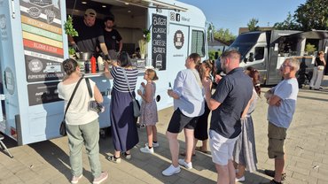 Menschen stehen in einer Schlange vor einem Foodtruck