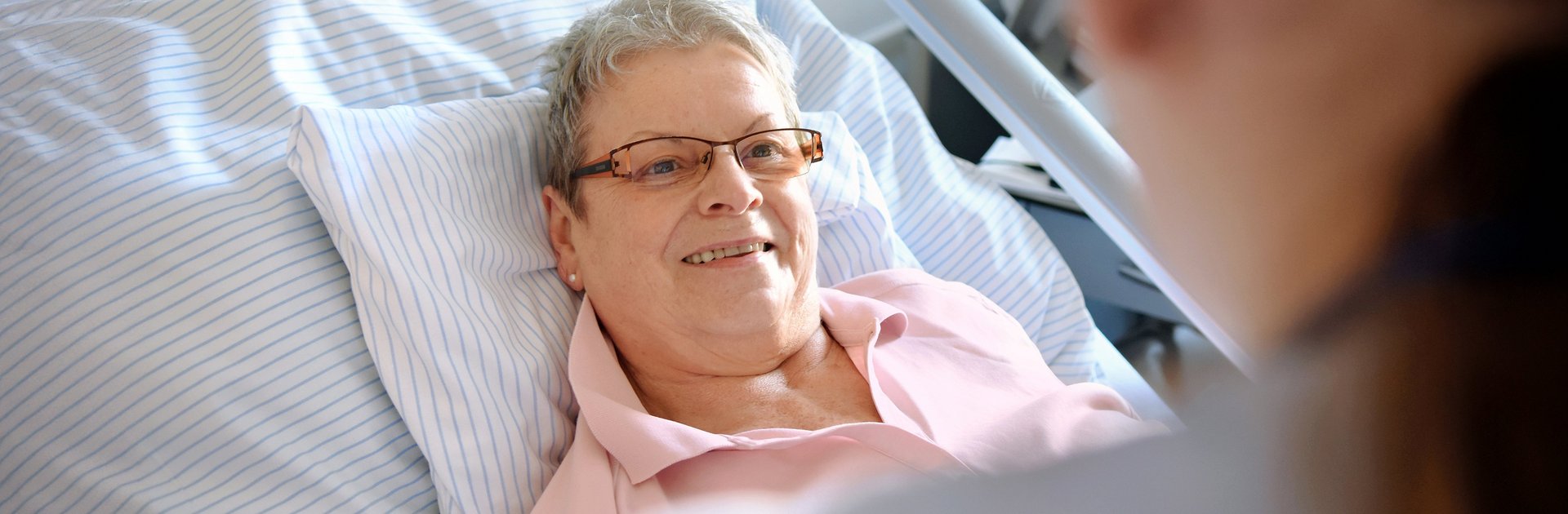 Frau liegt im Krankenhausbett