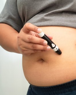 Person spitzt sich am Bauch