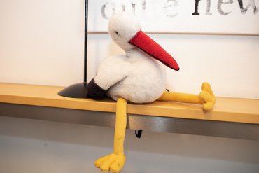 Plüschstorch auf Regalbrett