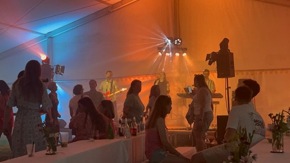 Menschen feiern im Festzelt (buntes Licht)