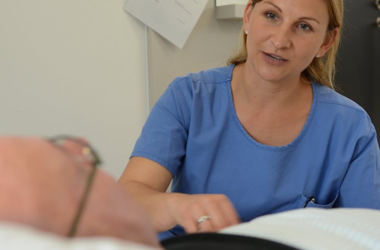 Pflegerin bei einem Patient am Bett